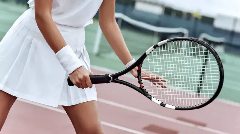 여성이 테니스 라켓을 들고 있는 모습